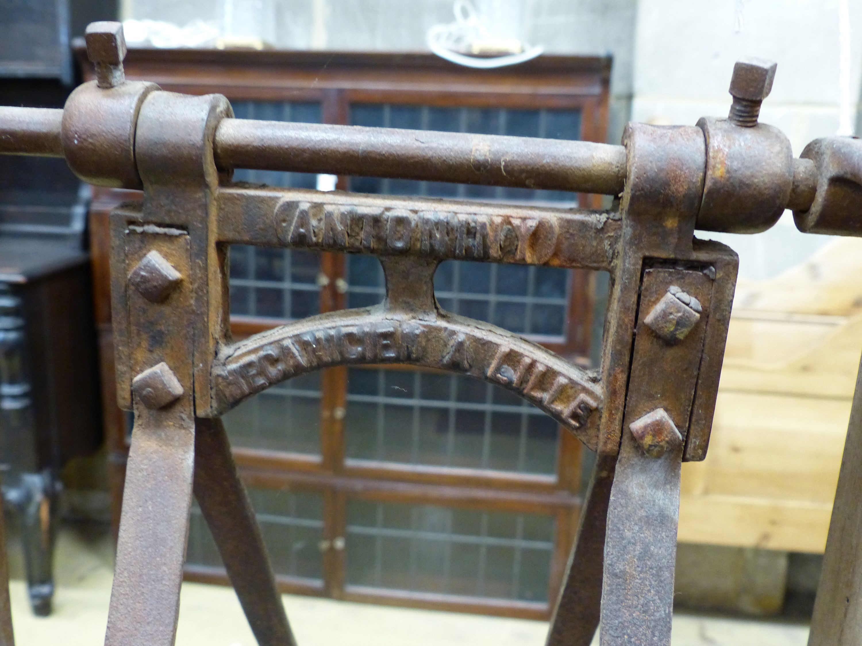 A late 19th century French Provincial (Lille) pine and wrought iron carding machine and two carding combs, length 113cm, height 120cm